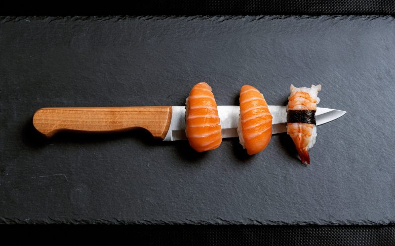 maki-sushi-edge-japanese-knife-black-graphite-background maki-sushi-edge-japanese-knife-black-graphite-background