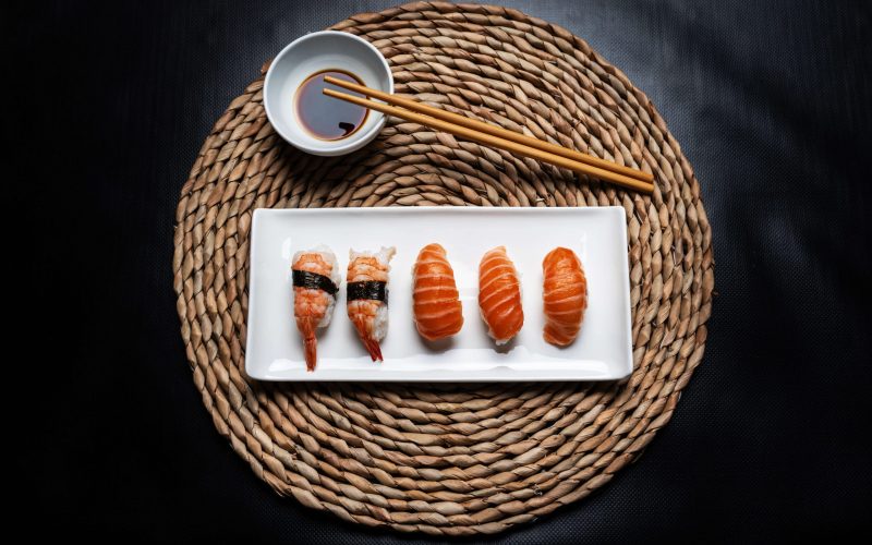 nigiri-sushi-white-ceramic-plate-with-chopsticks-bowl-with-soy-sauce-round-wicker-tablecloth-black-background nigiri-sushi-white-ceramic-plate-with-chopsticks-bowl-with-soy-sauce-round-wicker-tablecloth-black-background